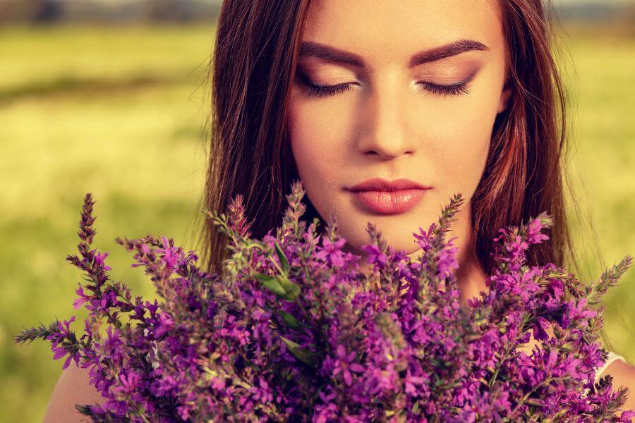 What is Sensory Overload Understanding the Causes Symptoms and Treatment Images of a Woman holding a bunch of lavender to help reduce sensory overload.