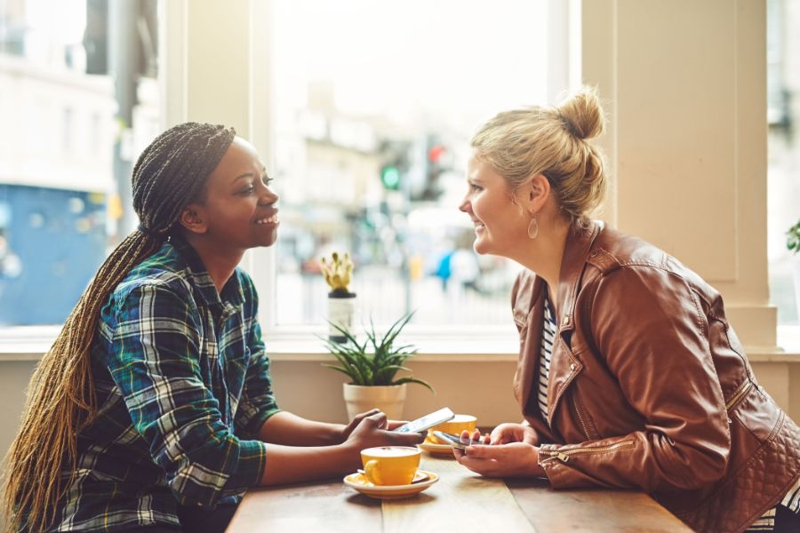 Safe Environment with two young women facing each other in a coffee shop